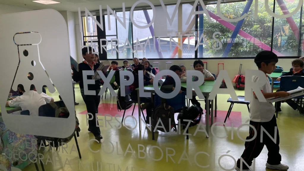 Actividad en un aula vista a través de un cerramiento de vidrio del Centro Educativo Sagrada Familia de Nazaret.